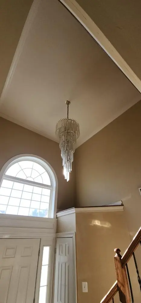 Long pendant chandelier in a two-story foyer