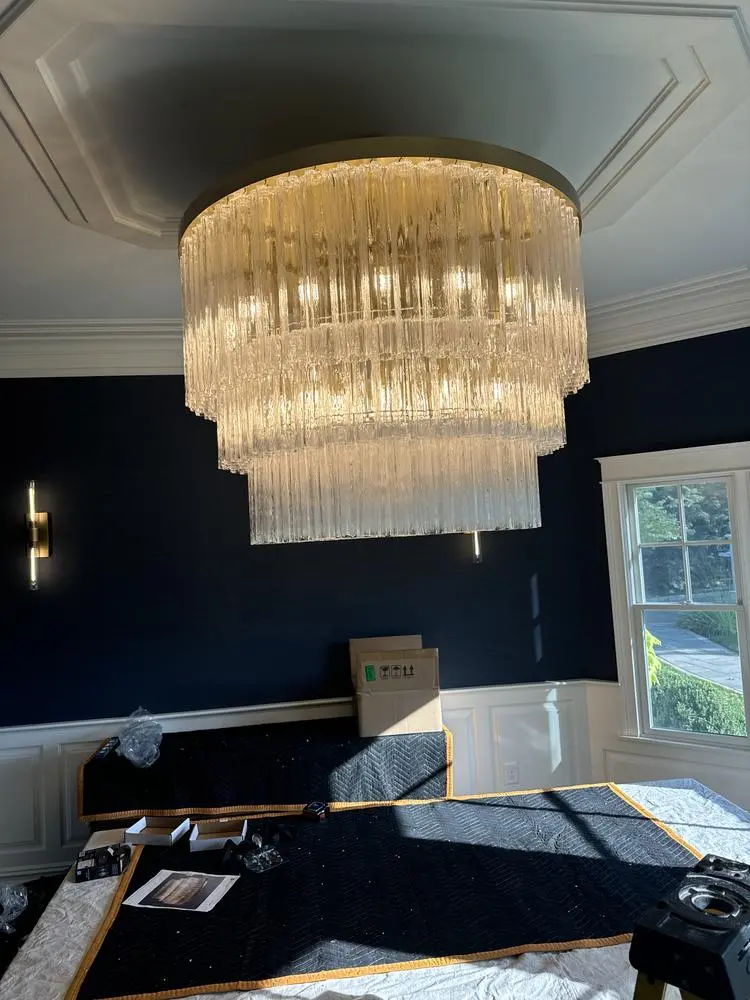 Dining room chandelier just installed, with the furniture still covered